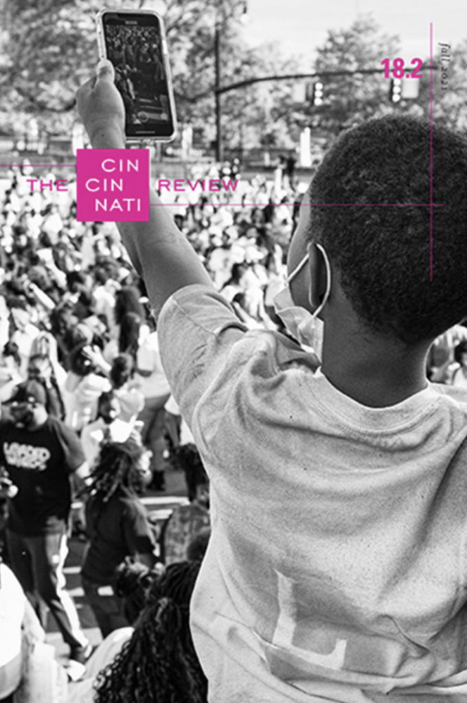 Cincinnati Review 18.2, December 2021, cover featuring a masked boy facing a crowd holding a phone.