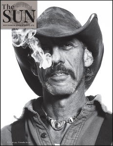 The Sun November 2023 featuring a black and white photograph of a white man with a mustache in a cowboy hat smoking.