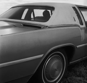 Cover image for “Please Be Patient, Student Driver” by Joseph Han, featuring a black and white photo of a vintage car up-close.