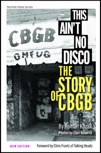 Cover of This Ain’t No Disco: The Story of CBGB by Roman Kozak, featuring white and yellow text over a black and white photograph of the graffitied exterior of CBGB.